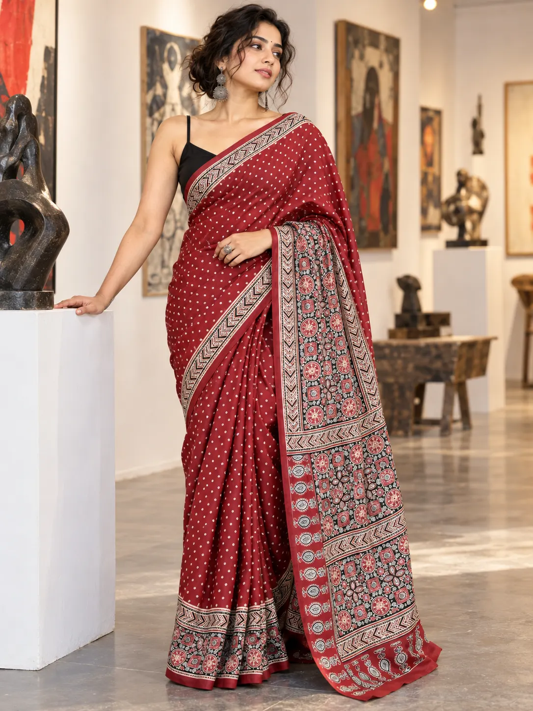 Kancholika deep red Ajrakh satin silk saree featuring fine Bandhani dot prints across the body, traditional geometric hand block printed borders, an elaborate artistic pallu, and feature callouts